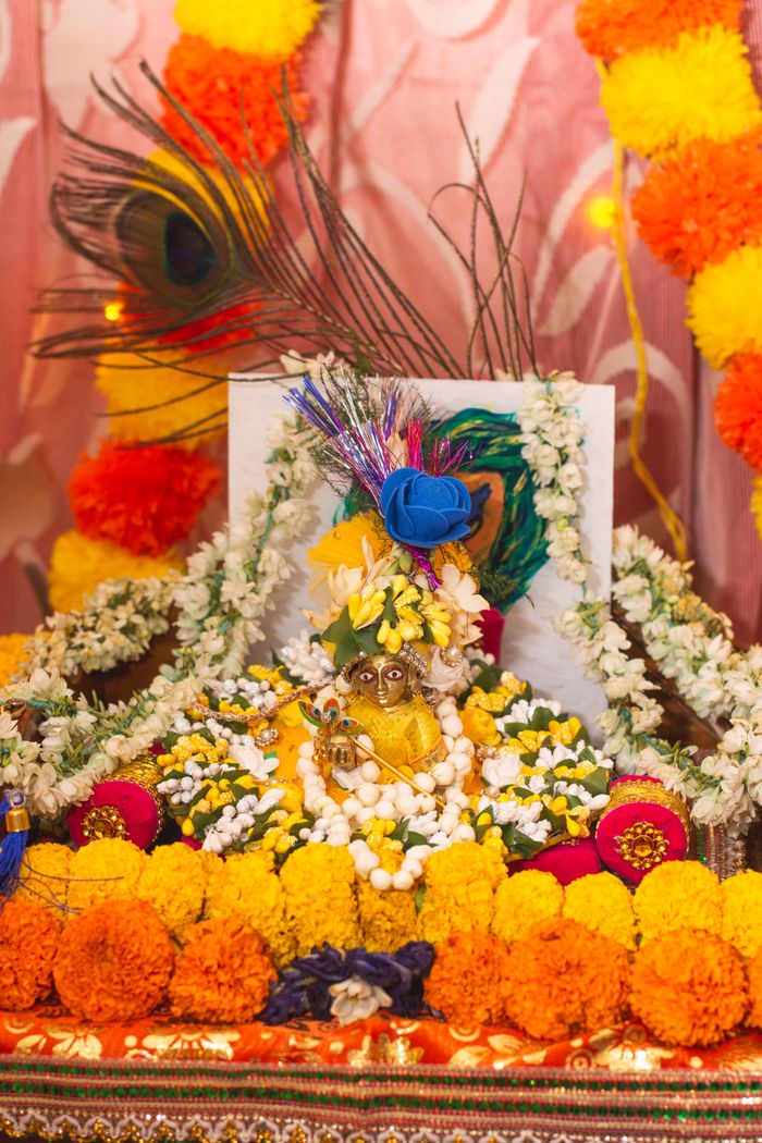 Colorful Indian altar adorned with flowers and traditional figurine, capturing cultural essence.
