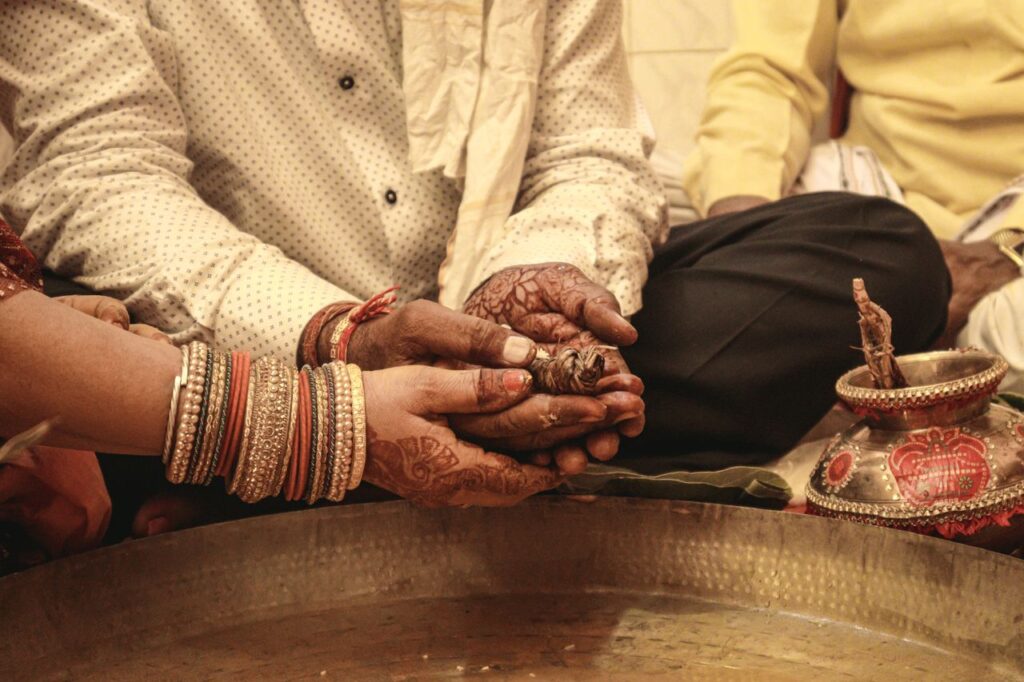 Close-up of hands in a Hindu wedding kanyadan ceremony, showcasing tradition.