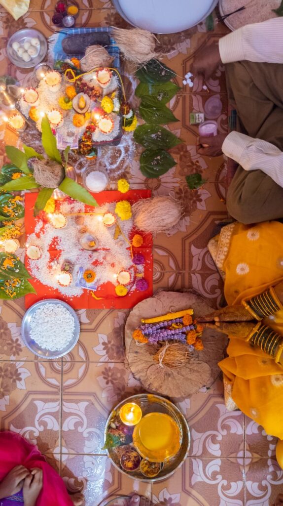 A vibrant Indian ceremony in Odhangi, MH with traditional offerings on a decorated floor.