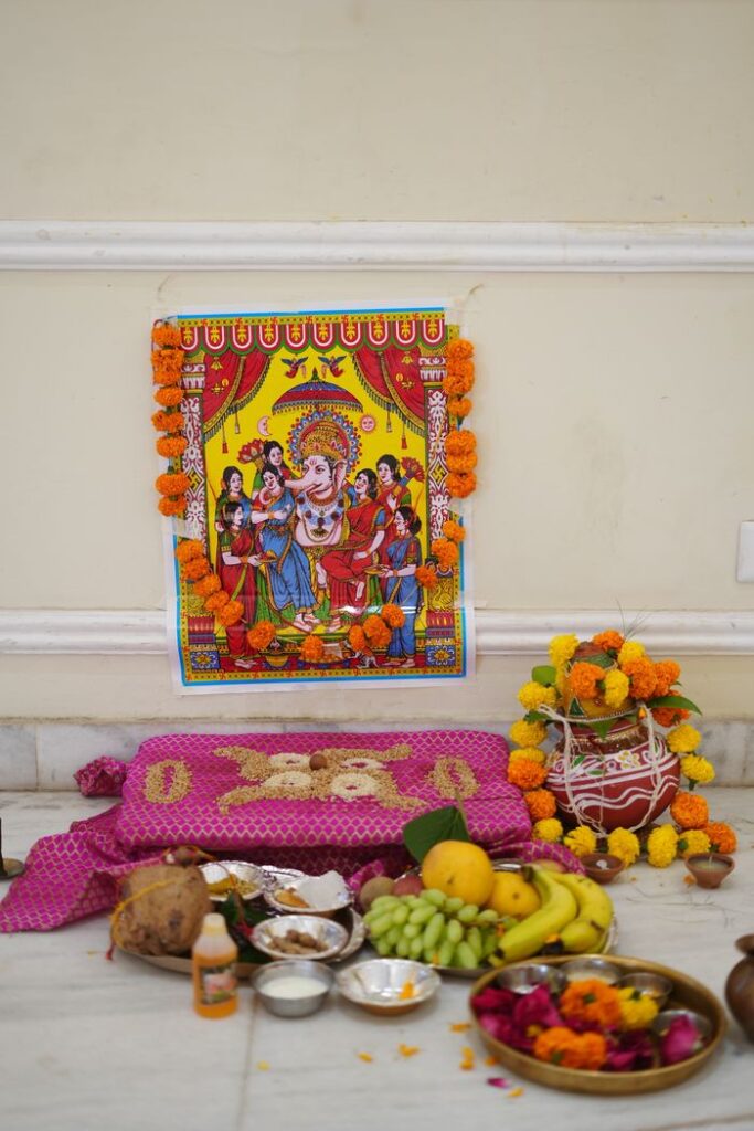 Colorful Ganesh puja altar with traditional offerings and marigold decorations.